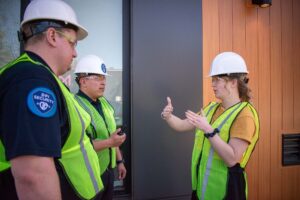 Woman in hardhat giving instruction to two DPI Security Officers
